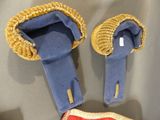 pair of blue slippers with gold trims and a red bow