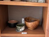 une étagère en bois sur laquelle sont posés des bols et des vases
