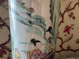 a vase with a painting on it sitting on a table