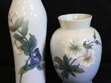 deux vases sur lesquels sont peints des fleurs sur fond noir