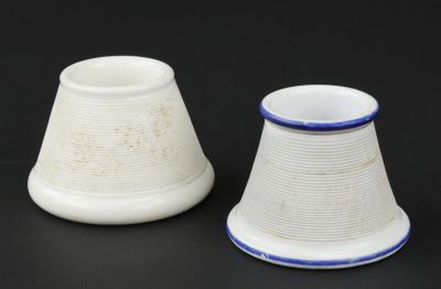 two white and blue vases sitting on a black surface
