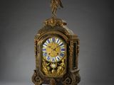 une horloge en or surmontée d'un oiseau