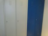 deux casiers bleus dans une pièce, près d'un mur blanc
