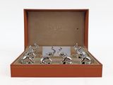 six silver figurines in a box on a white surface