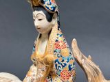 a figurine of a woman riding a horse with a dog