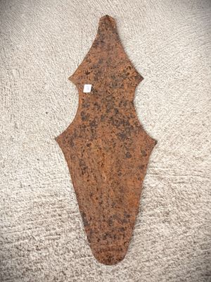 an old rusted metal arrow on a white carpet