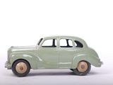 a green toy car that is sitting on a white surface