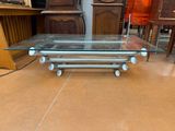 a glass coffee table with wheels on it in a room