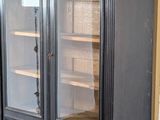 a black cabinet with a glass door in a room