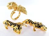 three gold rings with black and white enamel animals on them