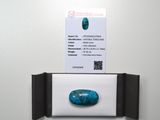 un gros plan sur une carte de visite et une pierre posée sur un mur