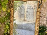un grand miroir posé par terre à côté d'un mur de briques