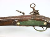 an old gun that is on display on a white surface