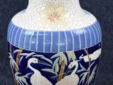 un vase bleu orné de motifs blancs et dorés
