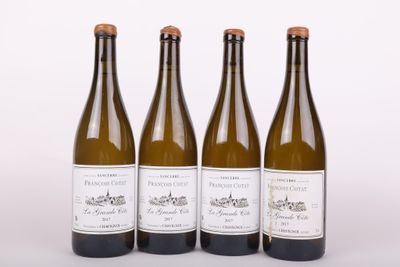 trois bouteilles de vin posées les unes à côté des autres sur une surface blanche