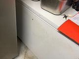 two pans of food sitting on a counter next to a freezer