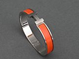 an orange and silver bracelet on a gray surface