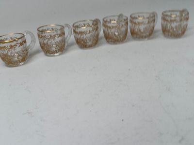 six glasses lined up in a row on a table