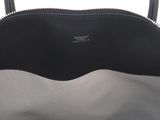the large black and grey bag is sitting on a white surface