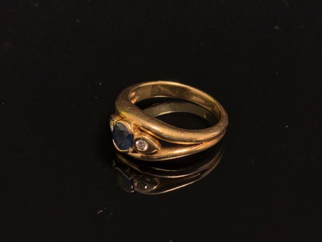 Bague en or 18 carats 750 millièmes à décor d’un saphir épaulé de...
