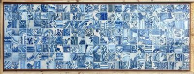 a picture of a blue and white tile mural on a brick wall