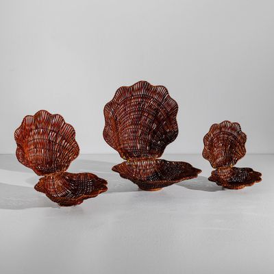 trois objets en osier sont disposés en rangée sur une surface blanche