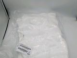 une chemise blanche emballée dans du plastique, posée sur une table blanche