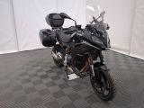 une photo d'une moto noire garée sur un sol à damier