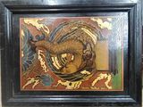 painting of a dragon in a black frame on a wall