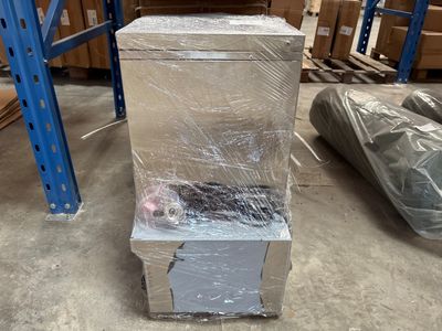 une boîte emballée dans du plastique et posée par terre
