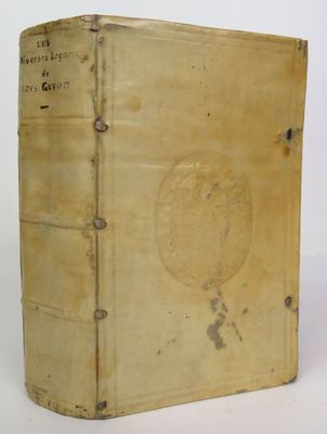 an old book sitting on top of a white table next to a white wall