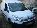 une petite camionnette blanche garée devant un mur de pierre
