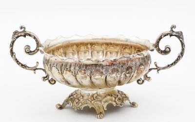 un bol ancien en argent, orné de poignées décorées sur fond blanc