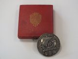 une pièce d'argent posée à côté d'une boîte rouge sur une table