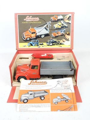 un camion jouet rouge dans une boîte sur laquelle figurent des instructions
