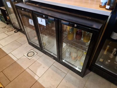 un comptoir muni d'une porte vitrée sur lequel sont disposées des bouteilles d'alcool
