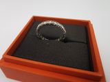 une boîte orange contenant une bague, posée sur une surface blanche