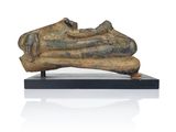 statue of a human foot on a wooden base