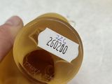 a person holding a bottle of liquid with a label on it