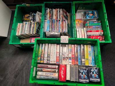 two green crates filled with dvds and dvds