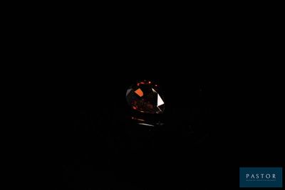 un diamant rouge dans l'obscurité, sur fond noir