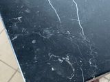 a marble table with a black top on a tiled floor