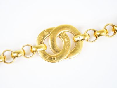 une image montrant un gros plan d'une chaîne en or sur laquelle est accrochée une bague