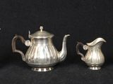four pieces of silver tea and coffee set on a black background
