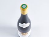 the bottle of wine is sitting on a white surface