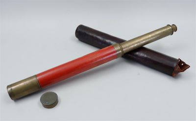 a red and gold pen sitting on top of a white table