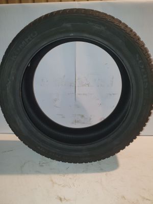 tire of a car on a white surface with a black rim