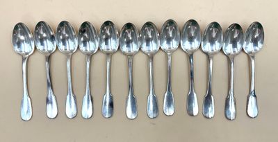 six cuillères en argent alignées en rang sur une table