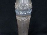 a glass vase that is sitting on a black surface