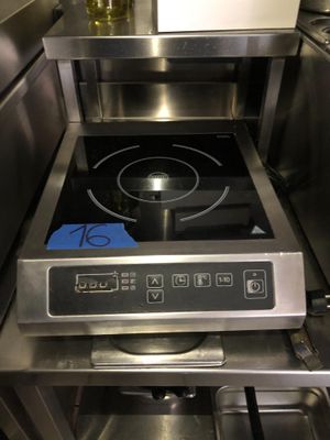 une cuisinière sur laquelle est posée une marmite dans une cuisine